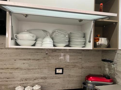 a cupboard filled with plates and bowls and dishes at La villa jasmin in Al Maqārisah