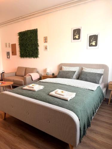 a bedroom with a large bed and a couch at Apartments Chloe - Top 4 in Hollabrunn