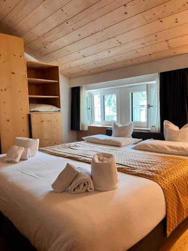 a bedroom with two beds with towels on them at Hotel La Meridiana in Madesimo
