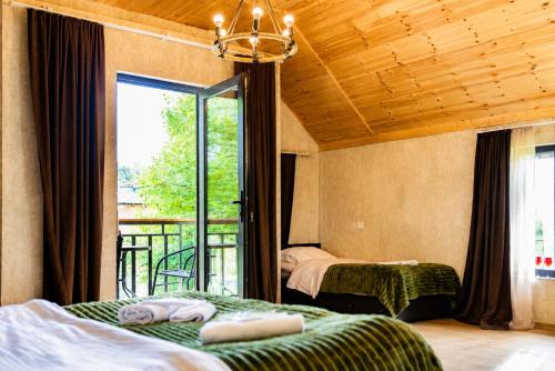 a bedroom with two beds and a balcony at Cottage Shina in Kazbegi