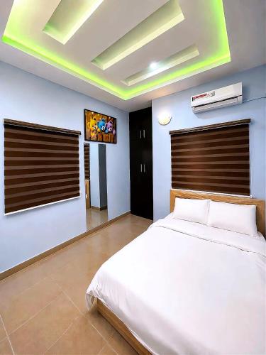 a bedroom with a white bed and a tv at Layiz Court in Lagos