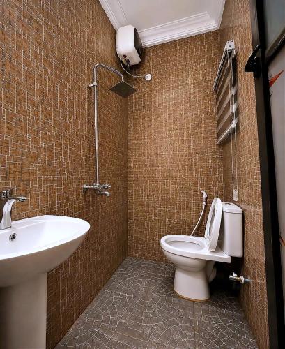 a bathroom with a white toilet and a sink at Layiz Court in Lagos