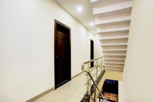 a stairway with a black door and a stair case at SPOT ON Hotel Shree Ji in Indore