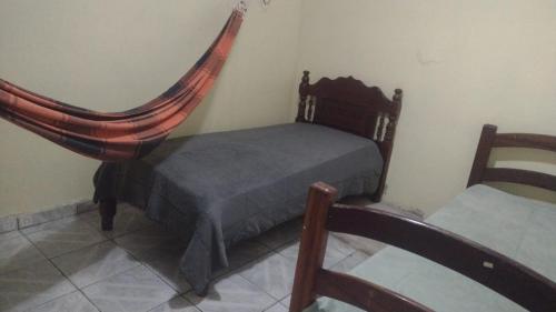 a bedroom with a bed and a hammock at Casa 2 quartos em frente a praia na cidade mística de colares a 96 quilômetros de Belém do Pará in Colares