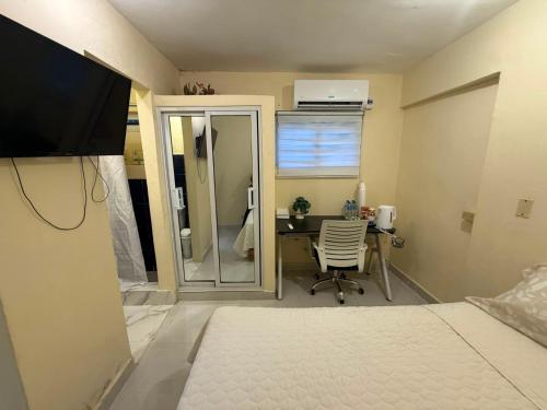 a bedroom with a desk and a bed with a television at Fantástico in Juan López