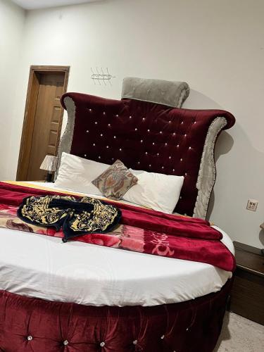 a bedroom with a bed with a red headboard at Pine view Hotel Tranna Balakot in Hassa