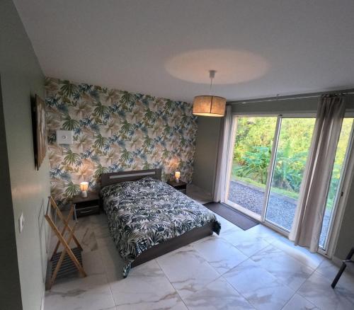 a bedroom with a bed and a large window at Chez Marie Line in Saint-Joseph