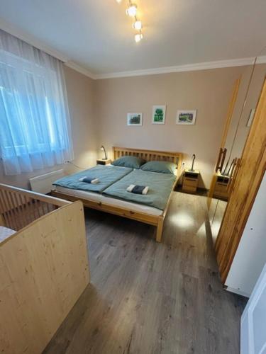 a bedroom with a bed with a green comforter at Csuszka vendégház in Tiszafüred