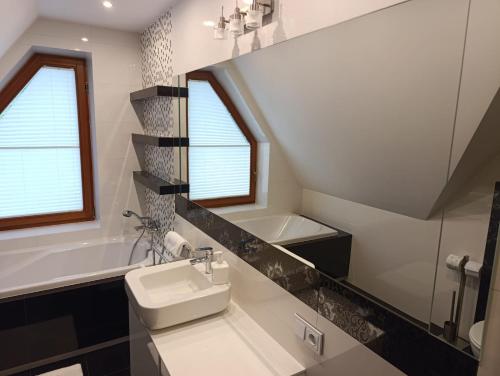 a bathroom with a sink and a bath tub at Secret Residence with Sauna & Private Pool in Kościelisko