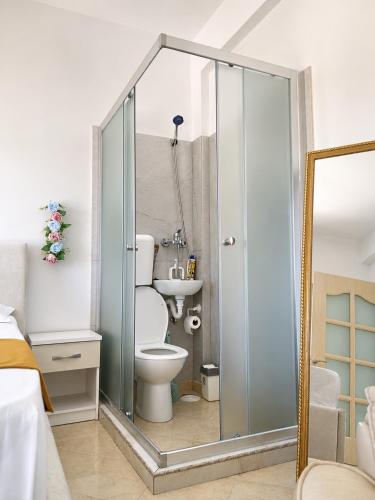 a bathroom with a shower with a toilet and a sink at Vila Dy Bukurite Durres in Draç