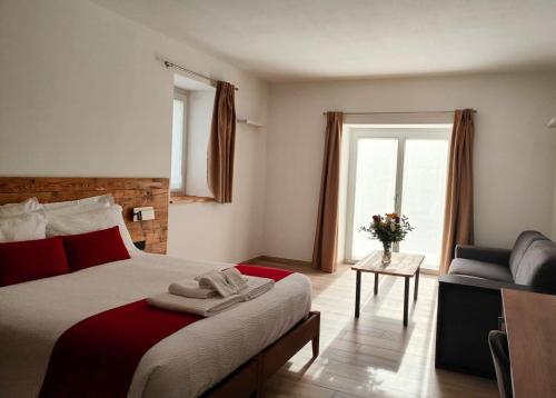 a bedroom with a bed and a chair and a window at Casa NovecentoSei in Sonico