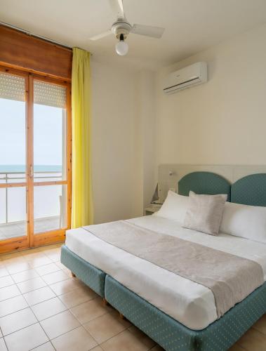 a bedroom with a bed with a view of the ocean at Hotel Embassy in Pesaro