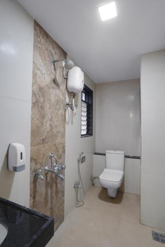 a bathroom with a toilet and a shower and a sink at Hotel Royal Comforts in Pune