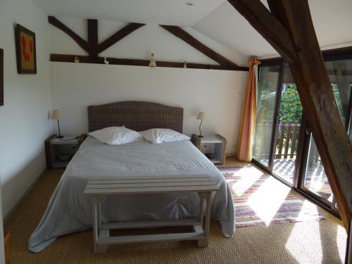 a bedroom with a large bed and a window at GITE Au Moulié in Blousson-Sérian