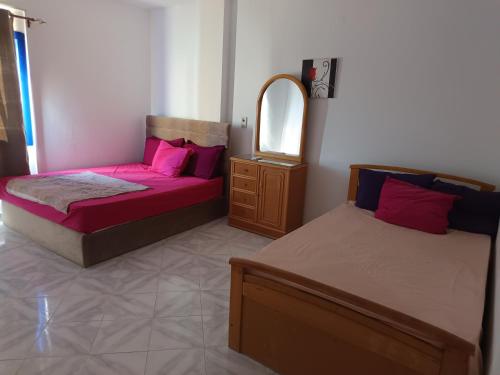 two beds sitting in a room with a mirror at Golden Beach 1 for family in Ras Sedr