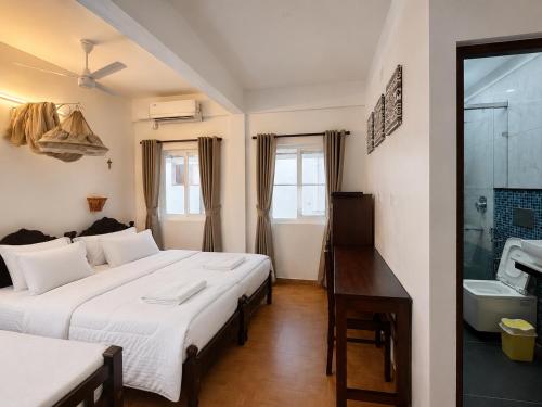 a bedroom with two beds and a desk in it at Reds Residency - Homestay in Cochin