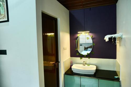 a bathroom with a sink and a mirror at CatsClaw Inn in Talayolaparambu