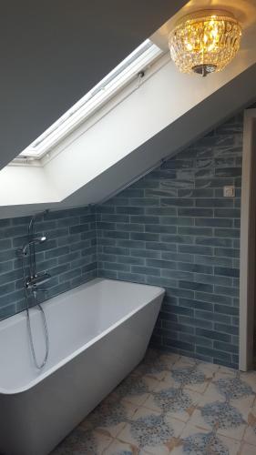 a bath tub in a bathroom with a chandelier at Långshyttans Brukshotell in Långshyttan