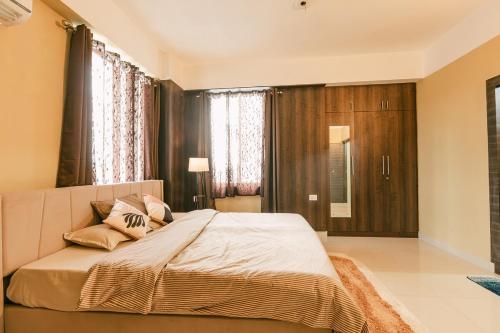 a bedroom with a large bed with pillows on it at CueCasa in Guwahati