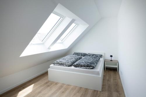 a bedroom with a bed under a roof with skylights at Alleenstraße 66 in Wendlingen am Neckar