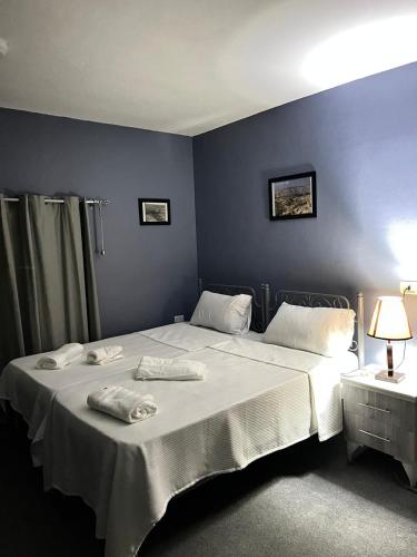 a bedroom with a bed with two towels on it at Beit Philodemus 2 - IRIS in Um Qeis