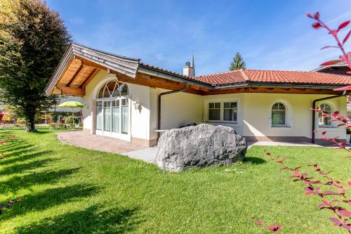 a house with a large rock in the yard at Berghof-Chalet in Erpfendorf
