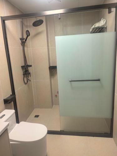 a bathroom with a toilet and a glass shower door at #1 Diamond Hotel and Residences in Georgetown