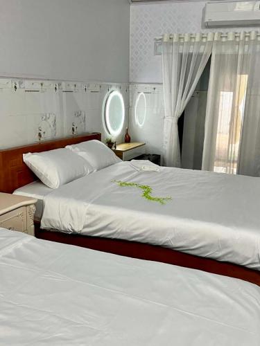 a bedroom with two beds and a window at Cát Home in Phú Hiệp