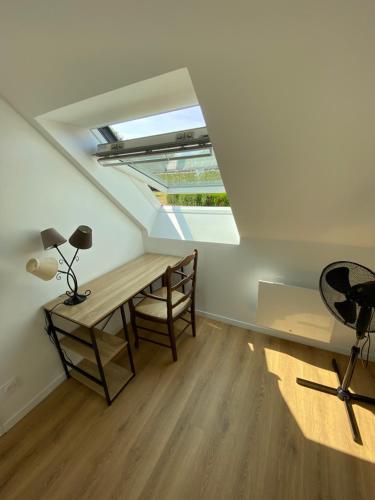 a room with a desk and a lamp and a window at La grange du clos in Angiens
