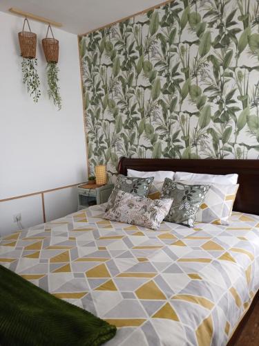a bedroom with a bed with a floral wallpaper at Les 4 Portes in Le Mesnillard