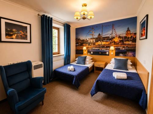 ein Hotelzimmer mit zwei Betten und einem Stuhl in der Unterkunft Hotel Bończa in Stettin