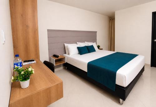 a bedroom with a king sized bed and a table at Hotel Campestre Santa Catalina in San Gil