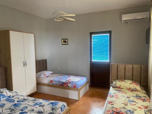a bedroom with two beds and a window and a door at Ankor view in Shëngjin