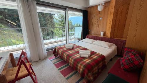 a bedroom with a bed and a large window at Appartamento Cinzia Residence Solaria Marilleva 1400 in Marilleva