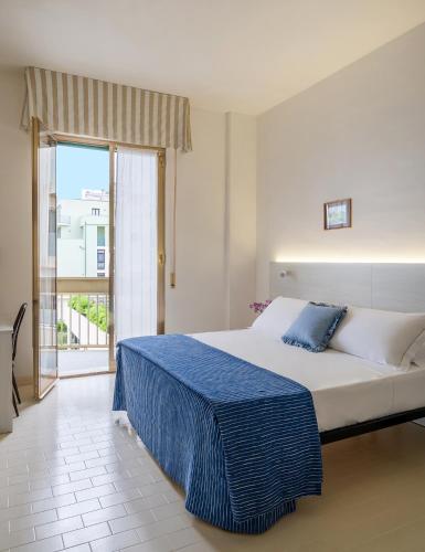 a bedroom with a large bed and a large window at Hotel Leonardo da Vinci in Pesaro