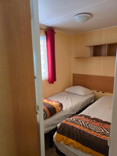 a small room with two beds and a window at Camping les sables in Aytré
