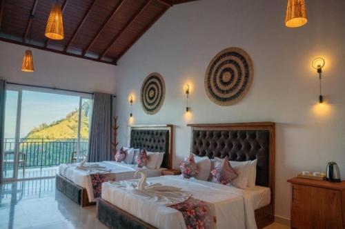 a bedroom with two beds and a balcony at Crystal springs mount face Hotel in Ella