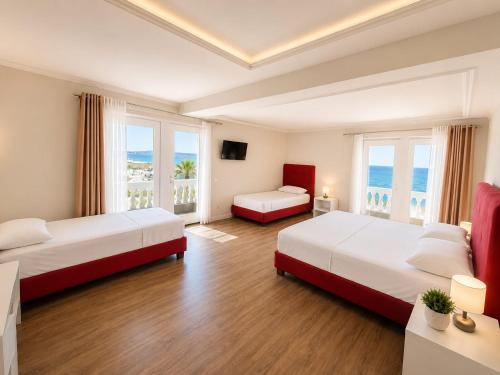 a hotel room with two beds and a large window at Shala Resort & SPA in Durrës