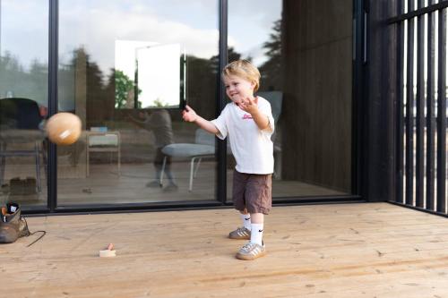 a young child playing with a ball in a room at Eco by Nature - De Stilte - in Heythuysen