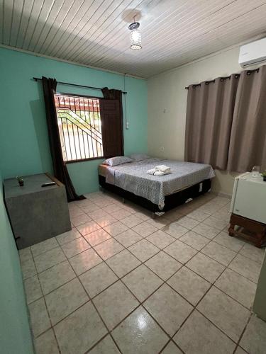 a bedroom with a bed in a room with a window at Bela Vista Pousada Alter in Alter do Chao