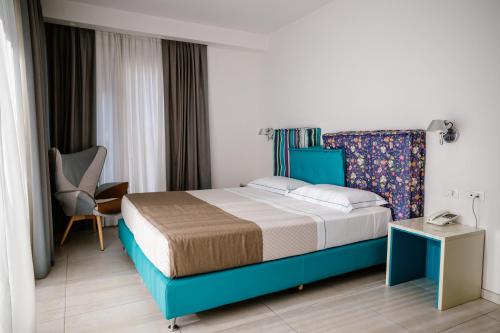 a bedroom with a bed and a chair and a table at Hotel Cicò in Torre Santa Sabina