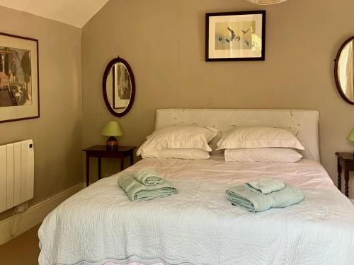 a bedroom with a bed with towels on it at Watercombe House in Wheddon Cross