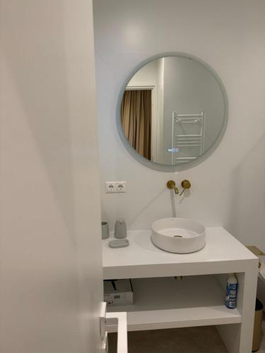 a white bathroom with a sink and a mirror at Rea's Luxury Suite Gialova in Gialova