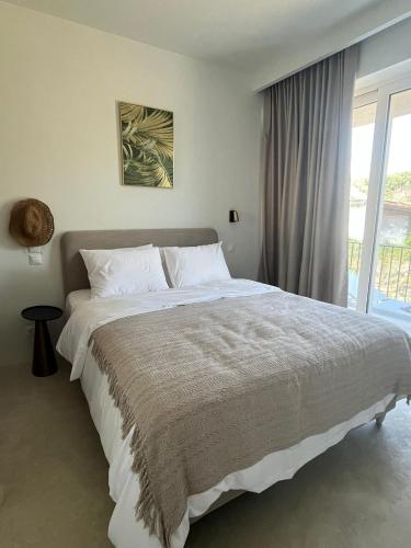 a bedroom with a large bed and a window at Rea's Luxury Suite Gialova in Gialova