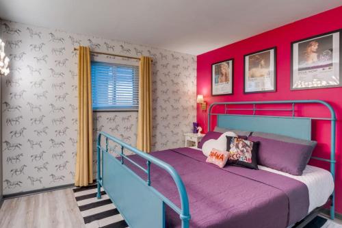 a bedroom with a blue bed and red walls at Chic Nashville Retreat, River Views and VIP Vibes in Nashville