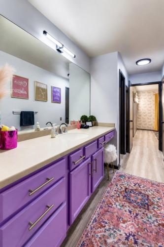 a bathroom with purple cabinets and a large mirror at Chic Nashville Retreat, River Views and VIP Vibes in Nashville