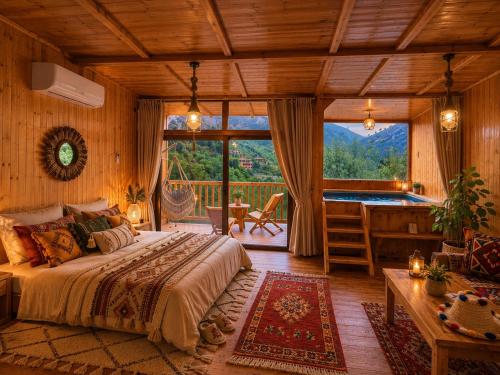 a bedroom with a bed and a desk and a large window at Afla views in Imlil