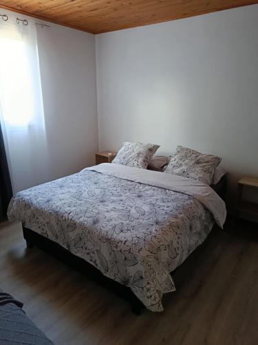 a bedroom with a bed with a comforter and pillows at LaKaz Pascale T2 climatisé pour 4 adultes 1 enfant in Ravine des Cabris