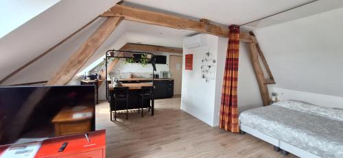 a bedroom with a bed and a desk with a tv at Les petits greniers in Jonquières