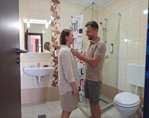 a man and a woman standing in a bathroom at Alma by iVAVev in Mamaia